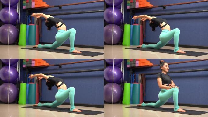 女孩通过铺板瑜伽姿势锻炼身体。瑜伽健身在工作室班，身体健康。