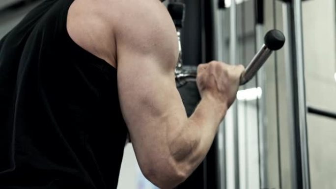 男性训练手臂肱三头肌肌肉使用电缆机进行体重。