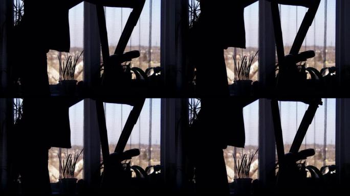 女孩练习的剪影在椭圆形训练器交叉训练器上在家靠窗
