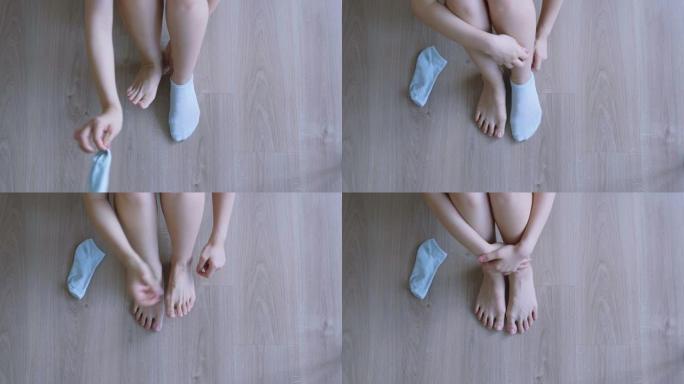 女人在地板上穿袜子