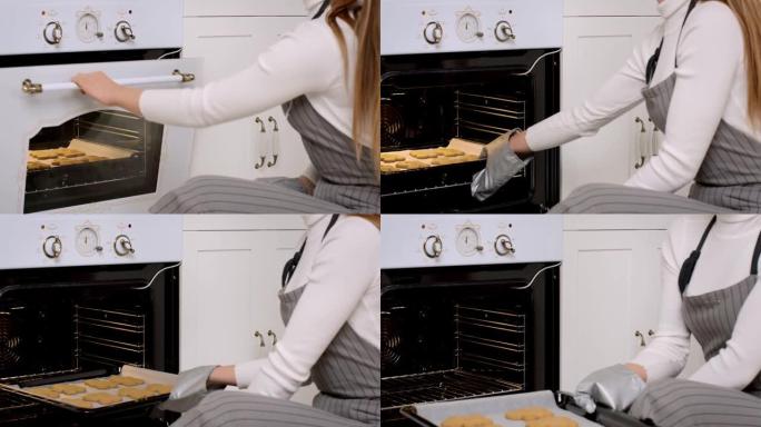 家庭主妇将烤盘和准备好的姜饼饼干从烤箱中取出的特写镜头，慢动作
