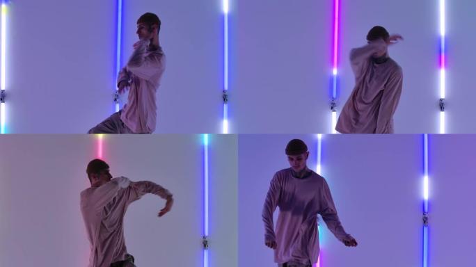 酷年轻有才华的嘻哈家伙在明亮的霓虹灯的背景下跳舞，表演惊人的手势和动作。街舞。特写。慢动作