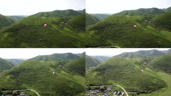 在山里滑翔伞。绿色的田野，山丘