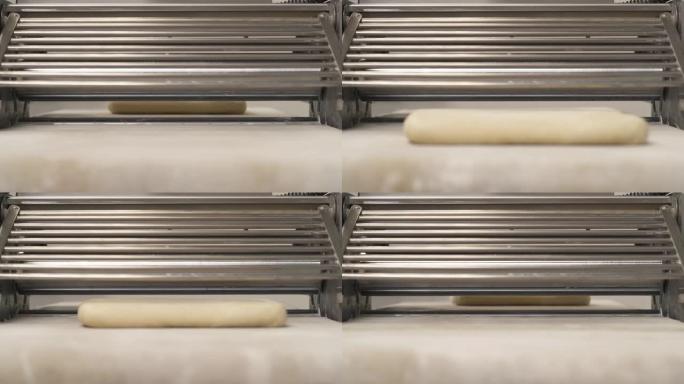面团压片机上的层压面团。在面包店生产羊角面包