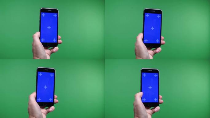 俄罗斯。莫斯科。2019。手机在手中近距离隔离在绿色背景。手机屏幕为蓝色色度键，背景色度键为绿色屏幕