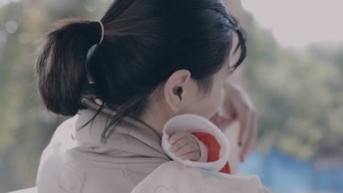 亚洲母亲抱着女婴，试图在慢动作镜头中平静和安慰她哭泣的婴儿。