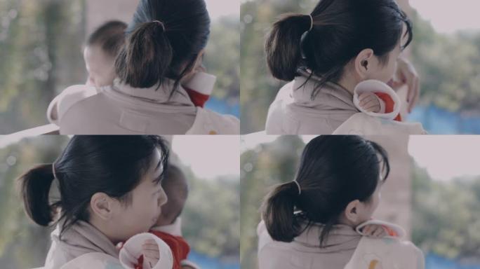 亚洲母亲抱着女婴，试图在慢动作镜头中平静和安慰她哭泣的婴儿。