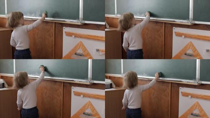 女孩在教室里用毛巾擦黑板。教育过程