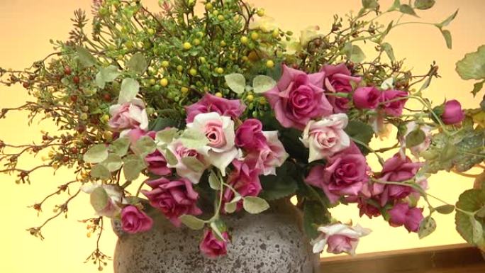 花瓶里的人造花束。带有美丽红花的花瓶。玫瑰花束人造花