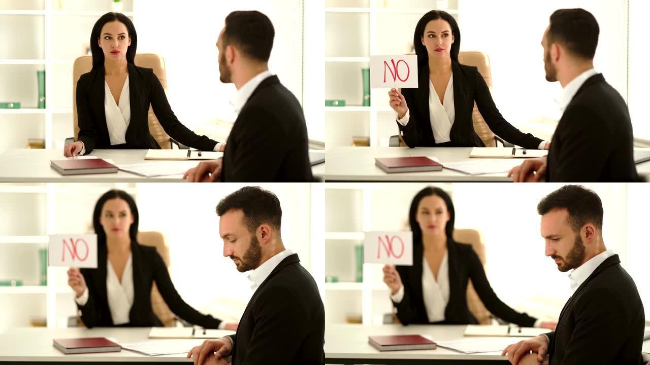 女人在办公室的桌子上采访一个男人