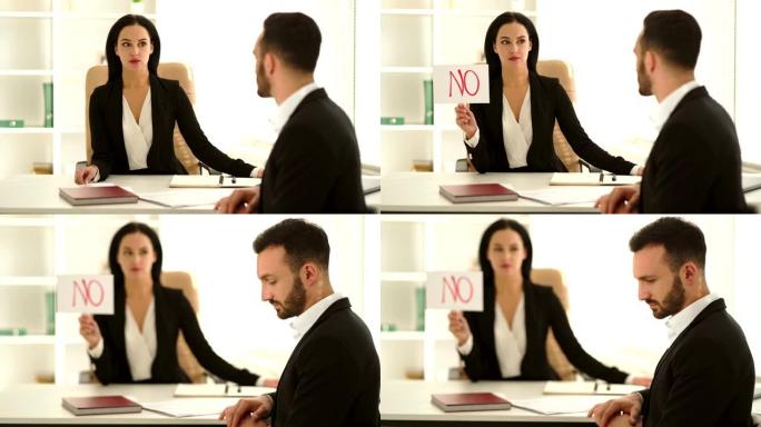 女人在办公室的桌子上采访一个男人