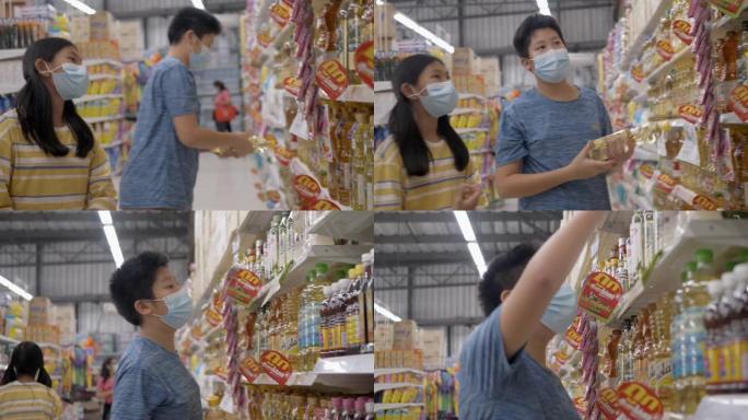 亚洲男孩和他的妹妹在新型冠状病毒肺炎前戴着口罩，为家人囤积食物，生活方式概念。
