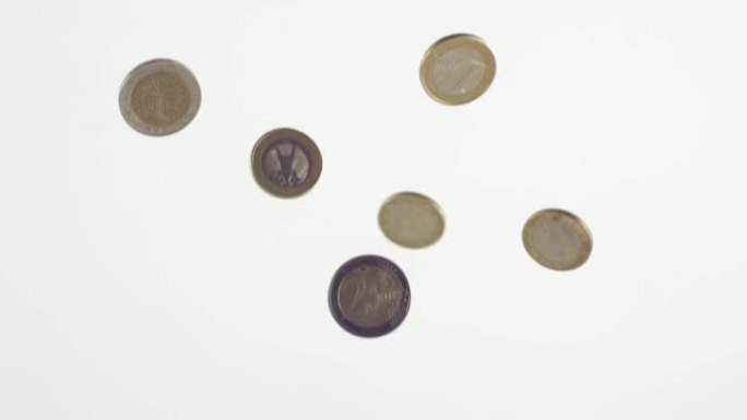 欧元硬币在白色背景前缓慢下落