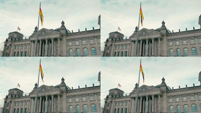 慢动作德国国旗在首都柏林市中心联邦议院议会大楼中央入口的背景下。在蓝色宁静的天空背景下。议会制与政治