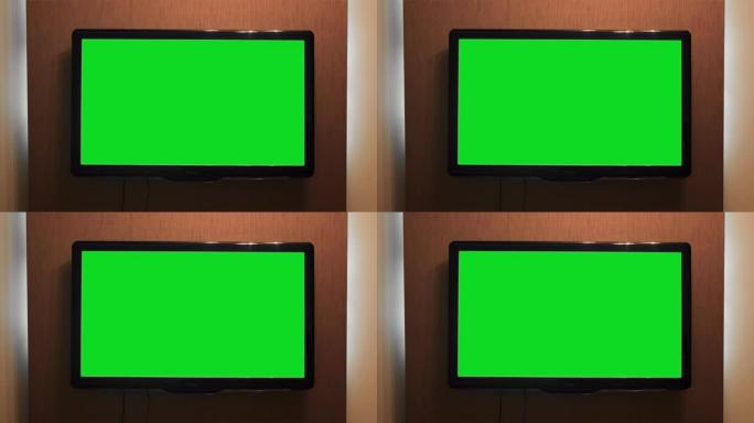 挂在墙上的绿屏电视。概念。房子墙上有绿屏的家庭电视。宽屏绿色背景等离子电视