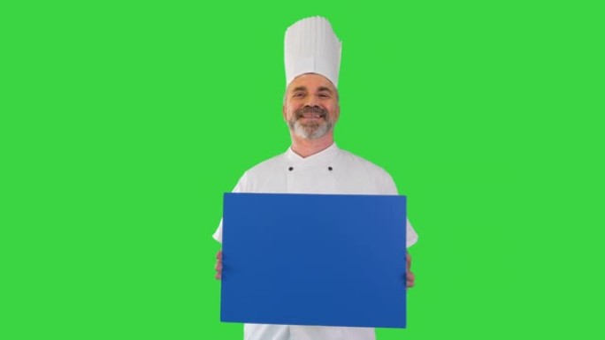 微笑的男厨师厨师在绿色屏幕上拿着空白板，色键