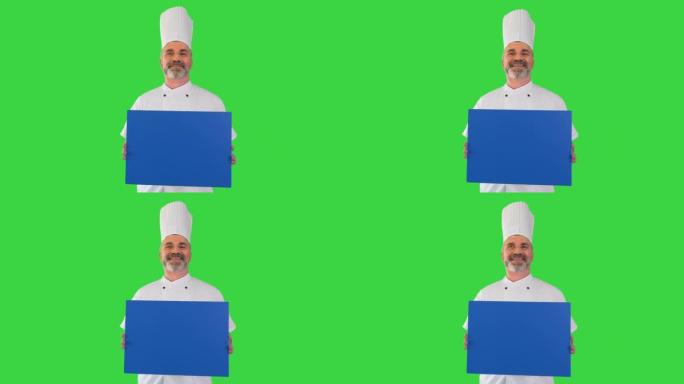 微笑的男厨师厨师在绿色屏幕上拿着空白板，色键