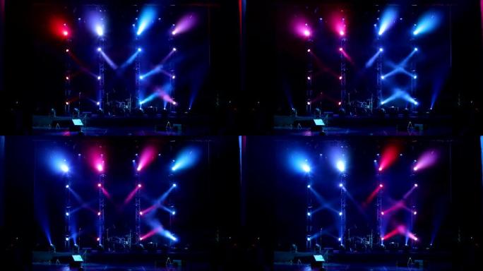 在黑暗中的空旷舞台上，五颜六色的灯光闪烁和白光