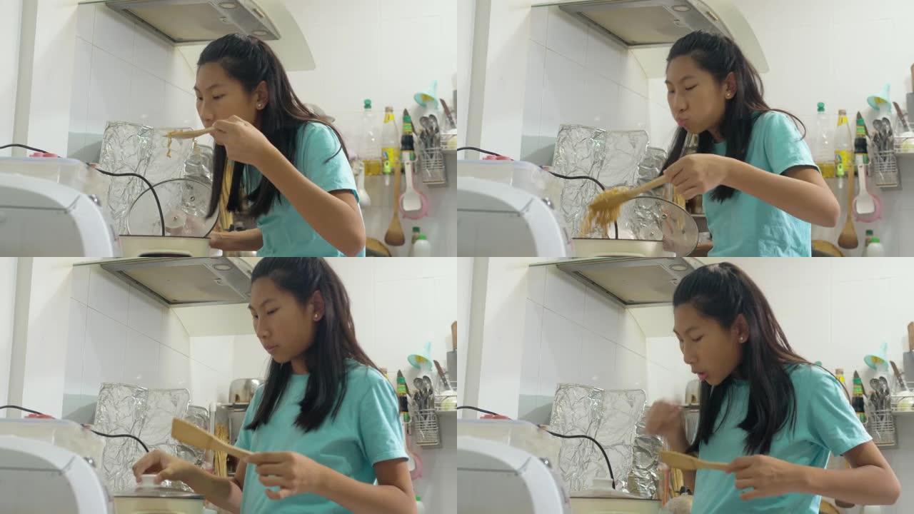 快乐的亚洲女孩在家厨房做饭，呆在家里的生活方式理念。