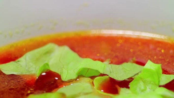 蔬菜红汤加奶油。厨师搅拌并加入生菜和奶油。小甜点勺子和碗。平稳旋转。