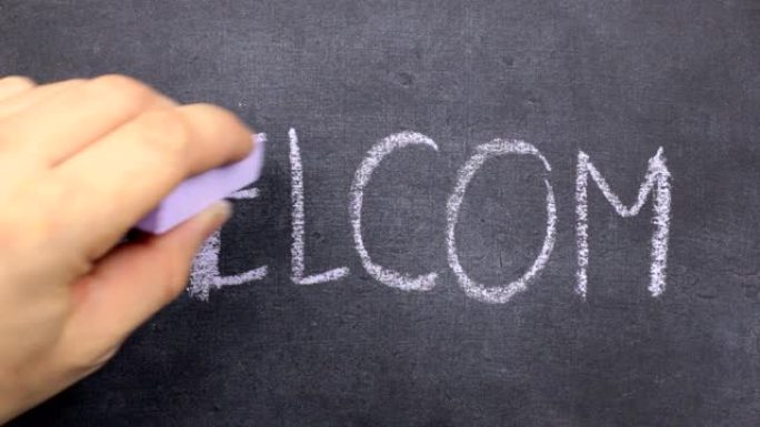 单词WELCOM用粉笔写在黑板上。用粉笔沿着轮廓划动。