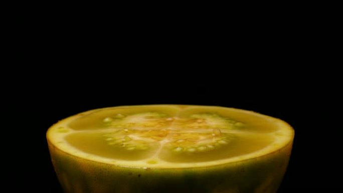 特写侧视图，茄子 (solanum quitoense naranjilla) 水果切成两半，在黑色