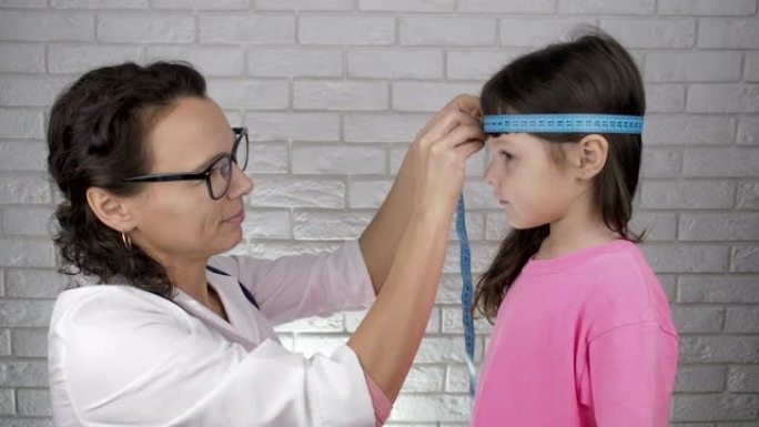 医生测量孩子的头部。