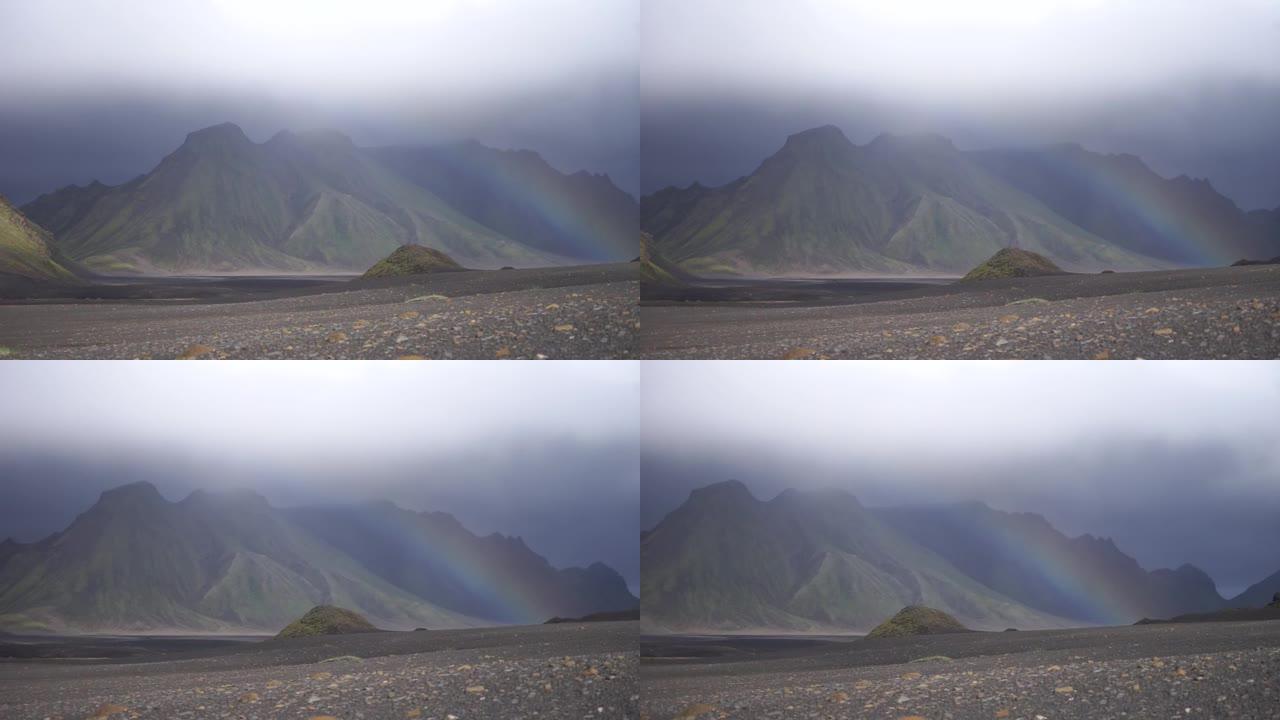 下雨时火山景观的全景，山上有彩虹。冰岛，Laugavegur徒步旅行
