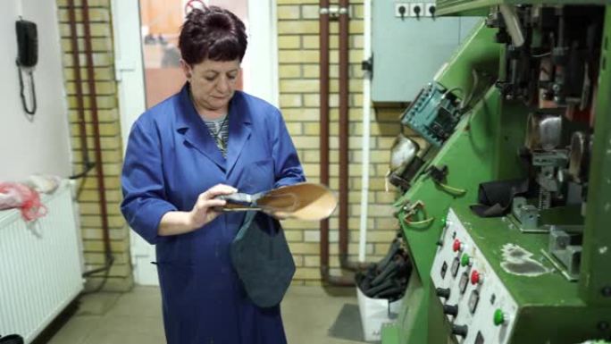 成熟的女士在机器鞋厂工作