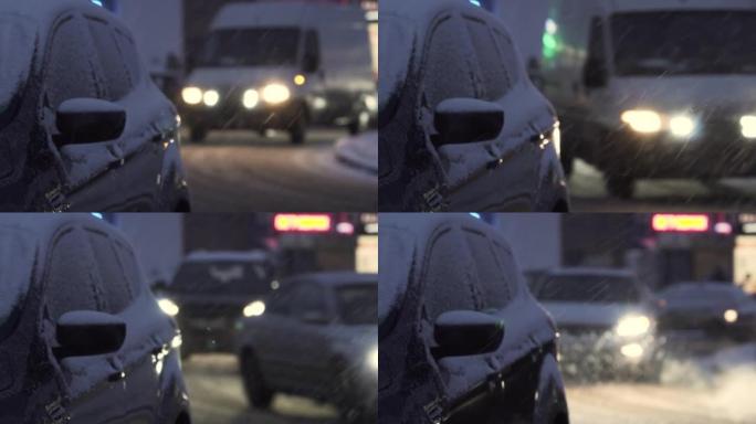 夜间降雪期间，汽车沿着积雪覆盖的城市道路行驶。高速公路上发生事故的危险。旋风期间的艰难路况