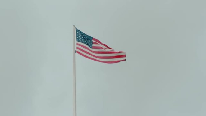慢镜头美国国旗上的星星和条纹映衬着蓝天。自由和民主的概念