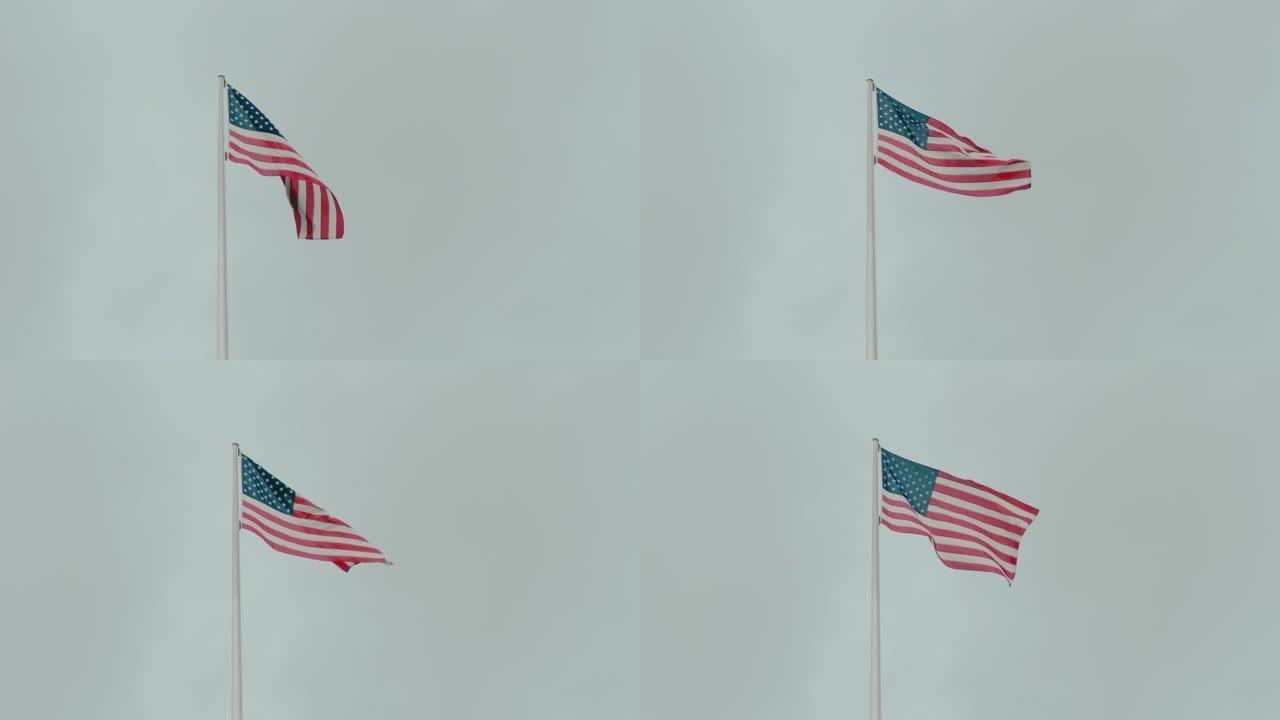 慢镜头美国国旗上的星星和条纹映衬着蓝天。自由和民主的概念