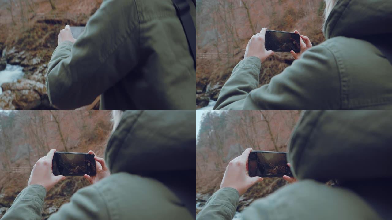 一名妇女用iPhone拍摄了一条河流穿过充满岩石的峡谷的照片。