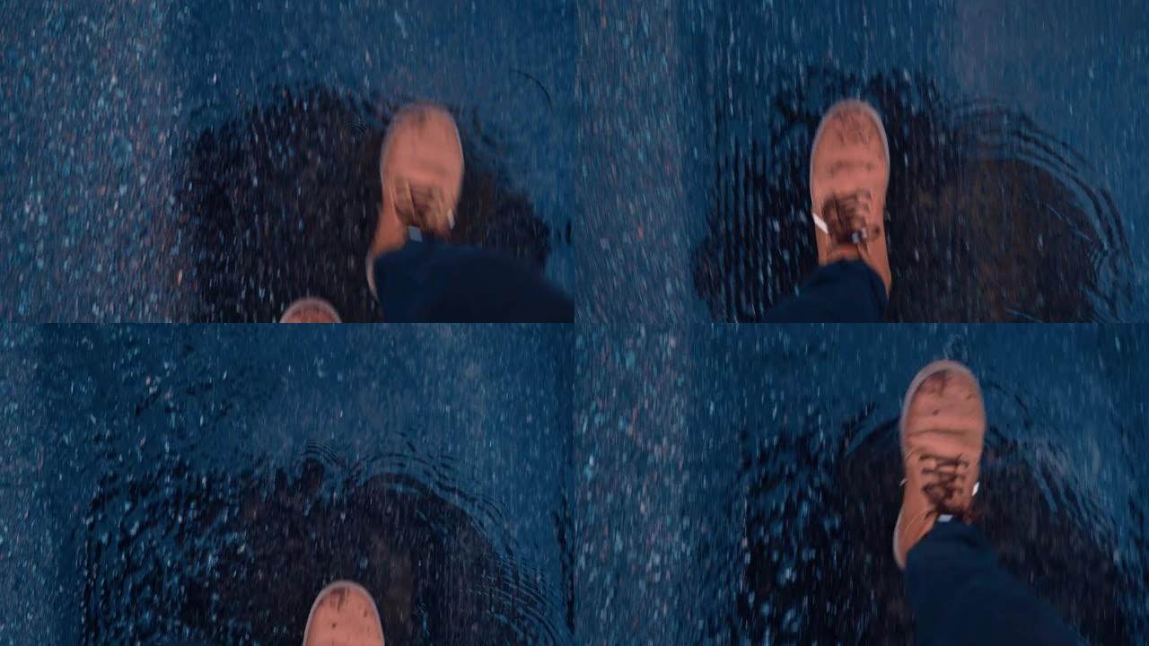 一个穿着湿棕色皮靴的人的脚在道路上的沥青水坑上行走的天顶视图。