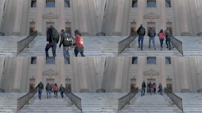 四名大学生走上楼梯前往公立大学的图书馆
