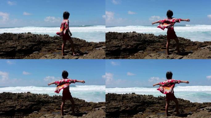 快乐的孩子们穿着五颜六色的夏威夷衬衫，享受观察毛里求斯附近一个岛屿岸边的大浪