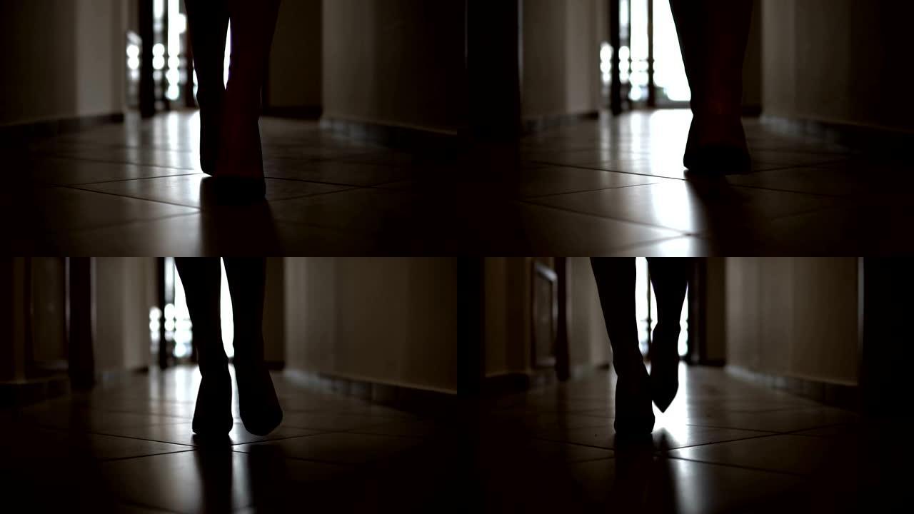 穿着高山鞋的时装模特在黑暗的走廊上行走的剪影，慢动作