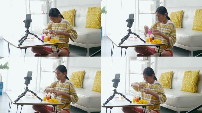 快乐的亚洲女孩在家中通过智能手机玩玩具和vlog视频作为YouTuber，现代生活方式概念。