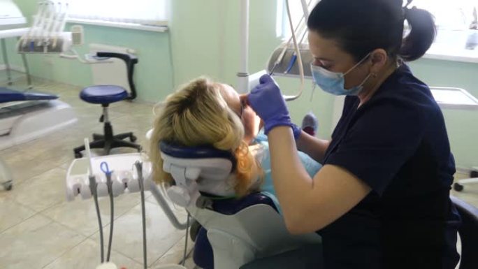 牙医招待会上的女孩。牙医在牙科诊所为病人治疗牙齿。