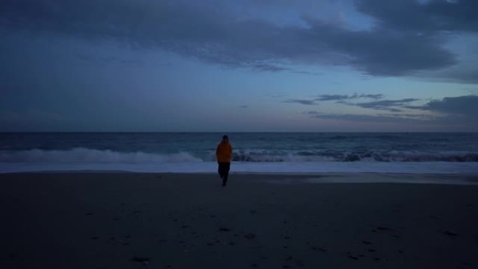 意大利利古里亚五渔村蒙特罗索阿尔马雷晚上在黄色夹克海滩跑步的男孩
