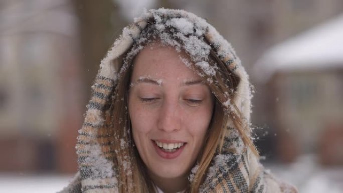 兴奋的女人摇了摇头，这样她就可以摆脱落在脸上和头发上的雪