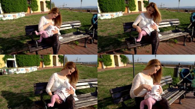 母亲在公园里母乳喂养婴儿