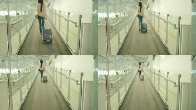 亚洲妇女在机场使用手机，戴医用口罩。