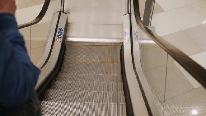 在购物中心的自动扶梯升降机上行走的匿名人士。