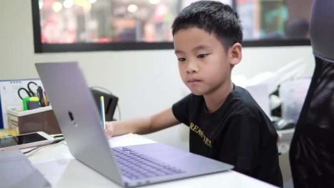 男孩使用笔记本电脑上在线课程。