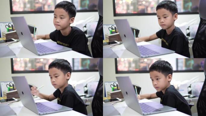 男孩使用笔记本电脑上在线课程。
