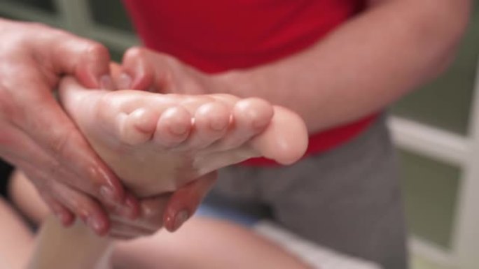 手动治疗师对年轻女性患者进行足弓按摩的特写演示视频。专业止痛治疗理念