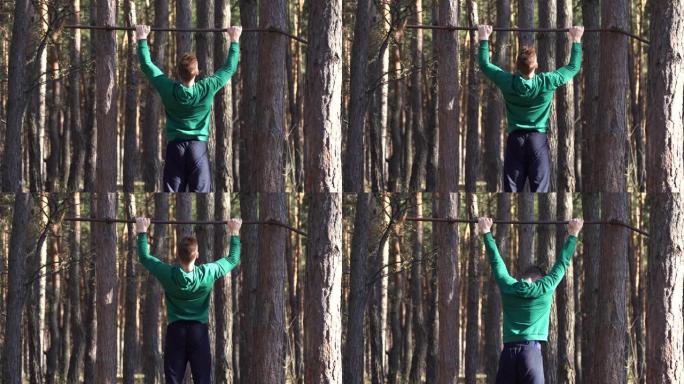 男人在森林里的单杠上锻炼。健康的生活方式