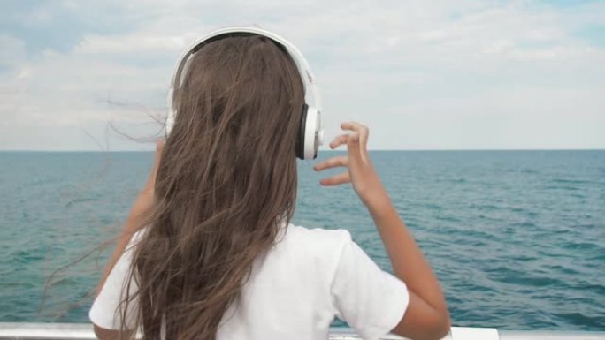 孩子在海边戴上耳机。