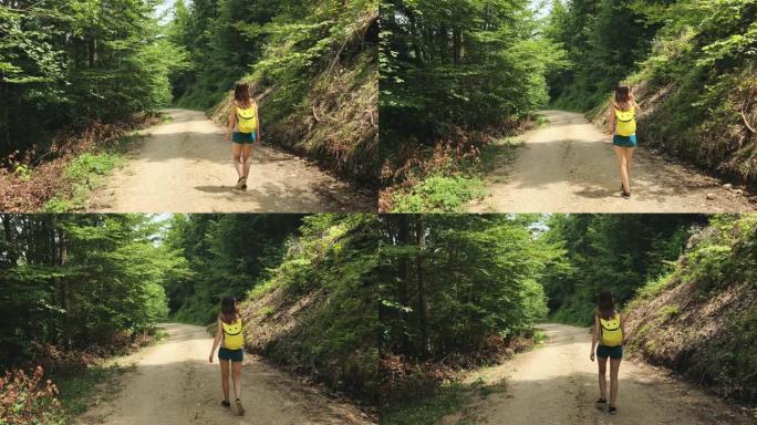一位年轻的女旅行者在野性中背着黄色背包走在乡间小路上